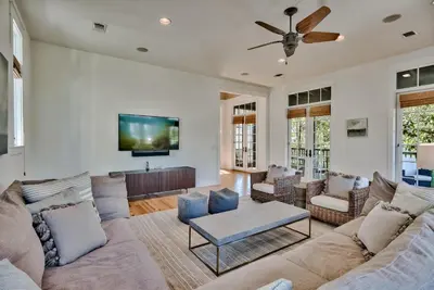 a living room with a couch and a tv at Bella Cottage in Rosemary Beach