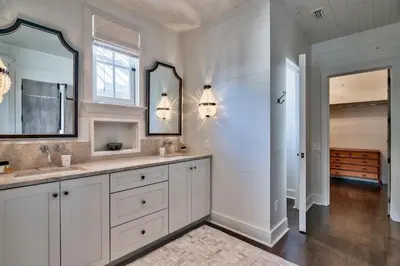 a white bathroom with two sinks and a mirror at Gates Cottage in Rosemary Beach
