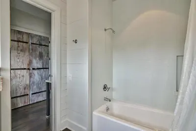 a white bathroom with a tub and a shower at Gates Cottage in Rosemary Beach
