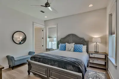 a bedroom with a large bed and a chair at Gilligan's Island in Inlet Beach