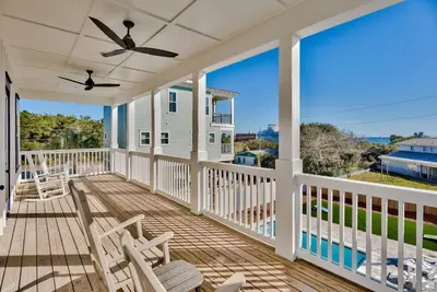 a porch with chairs and a ceiling fan at Gilligan's Island in Inlet Beach