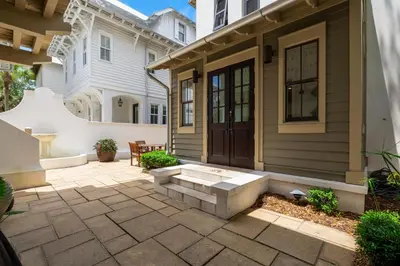 a house with a patio with a wooden door at PTO Cottage in Rosemary Beach