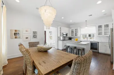 a kitchen and dining room with a wooden table and chairs at PTO Cottage in Rosemary Beach