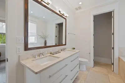 a bathroom with a sink and a mirror at PTO Cottage in Rosemary Beach
