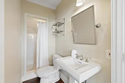a white bathroom with a sink and a toilet at PTO Cottage in Rosemary Beach