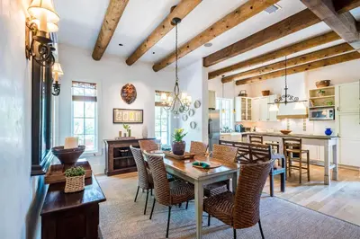 a kitchen and dining room with a table and chairs at Belize Cottage in Rosemary Beach