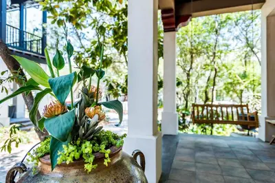 a vase with a plant in it on a porch at Belize Cottage in Rosemary Beach
