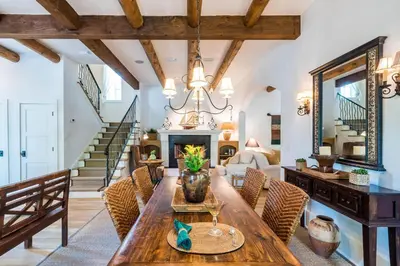 a living room with a table and a fireplace at Belize Cottage in Rosemary Beach