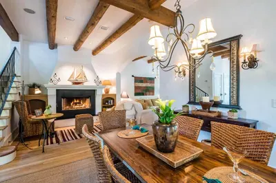 a dining room with a table and a fireplace at Belize Cottage in Rosemary Beach