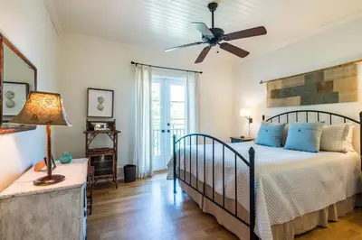 a bedroom with a bed and a ceiling fan at Belize Cottage in Rosemary Beach