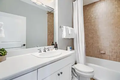 a white bathroom with a sink and a toilet at Percy's Flat in Rosemary Beach