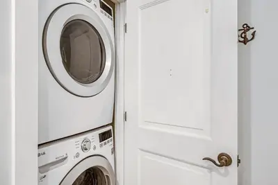 a white washer and dryer next to a door at Percy's Flat in Rosemary Beach