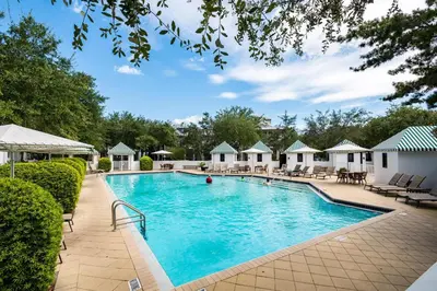 a swimming pool at a resort with chairs and trees at Percy's Flat in Rosemary Beach