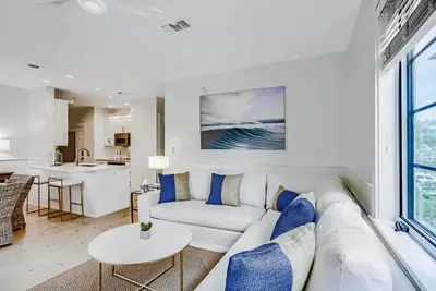 a living room with a white couch and a table at Percy's Flat in Rosemary Beach