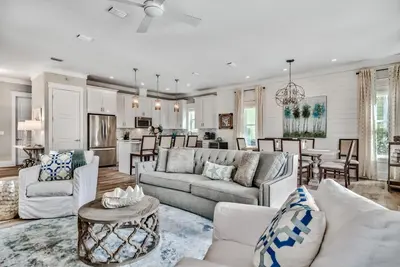 a living room with white furniture and a kitchen at Turquoise Turtle in Seacrest