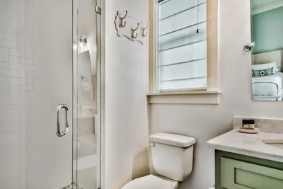 a bathroom with a toilet and a glass shower at Turquoise Turtle in Seacrest