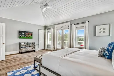 a white bedroom with a large bed and windows at Turquoise Turtle in Seacrest
