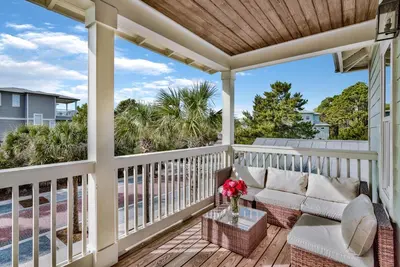 a porch with a couch and a table at Turquoise Turtle in Seacrest