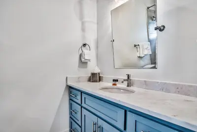 a bathroom with a blue sink and a mirror at Turquoise Turtle in Seacrest