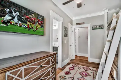 a living room with a tv on a wall at Turquoise Turtle in Seacrest