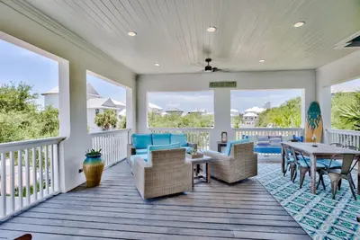 a porch with chairs and a table on a deck at Seaspell Sands in Santa Rosa Beach