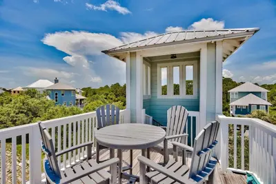 a table and chairs on a porch with a gazebo at Seaspell Sands in Santa Rosa Beach