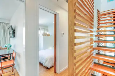 a room with a door leading to a bedroom at Astley Cottage in Rosemary Beach