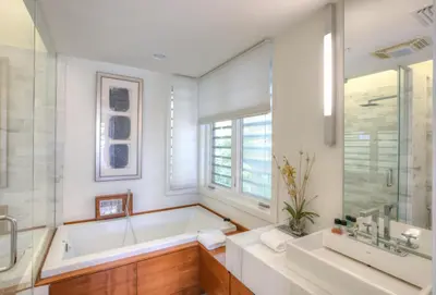 a bathroom with a tub and a sink at Astley Cottage in Rosemary Beach