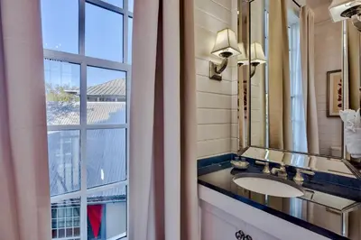 a bathroom with a sink and a large window at Highland Cottage in Rosemary Beach