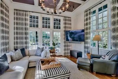 a living room with a couch and a table at Highland Cottage in Rosemary Beach