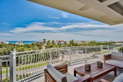 a balcony with a view of the ocean at Legacy Alexander at Palm Court in Seacrest
