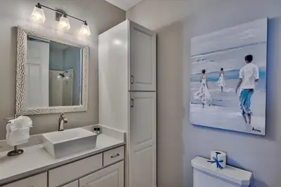 a white bathroom with a sink and a mirror at Legacy Alexander at Palm Court in Seacrest