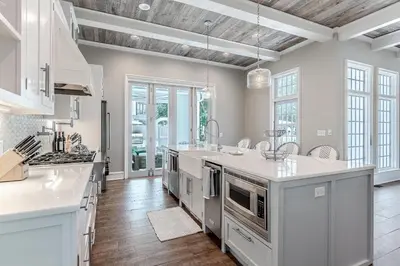 a kitchen with white cabinets and a large kitchen island at Carefree Cottage in Rosemary Beach