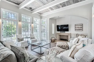 a living room with white furniture and a tv at Carefree Cottage in Rosemary Beach