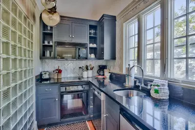 a kitchen with blue cabinets and a sink at Highland Carriage House in Rosemary Beach