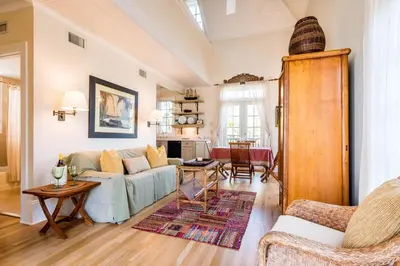 a living room with a couch and a table at Belize Carriage House in Rosemary Beach