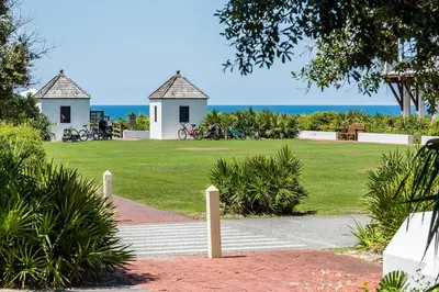 a park with two gazebos and the ocean at Belize Carriage House in Rosemary Beach