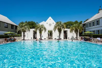 a large swimming pool in front of a building at Belize Carriage House in Rosemary Beach