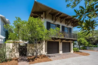 a house with a balcony on top of it at Belize Carriage House in Rosemary Beach