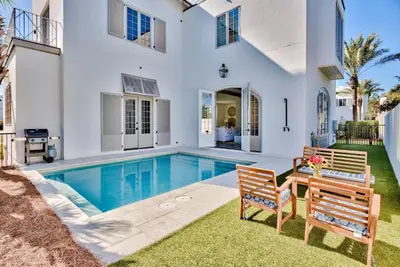 a house with a swimming pool and a table and two chairs at Elysee Retreat in Seacrest