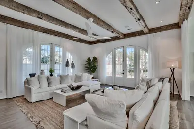 a living room with white furniture and windows at Elysee Retreat in Seacrest