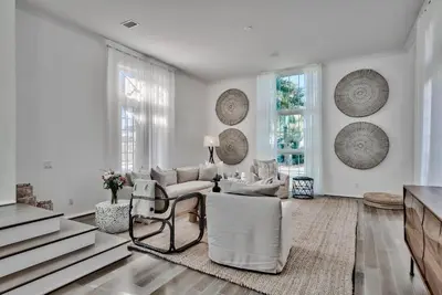 a living room with white furniture and large windows at Elysee Retreat in Seacrest
