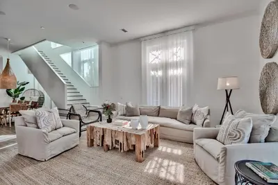 a living room with white furniture and a table at Elysee Retreat in Seacrest