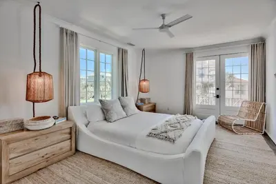 a white bedroom with a large bed and windows at Elysee Retreat in Seacrest