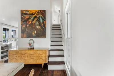 a staircase in a home with a painting on the wall at Acqua Cottage & Carriage House in Rosemary Beach