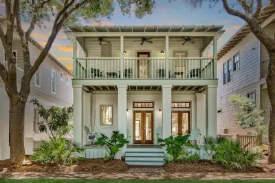 a large white house with a balcony at McKenzie Cottage in Rosemary Beach
