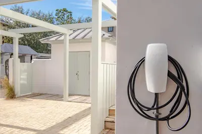 a white house with a hose attached to a wall at McKenzie Cottage in Rosemary Beach