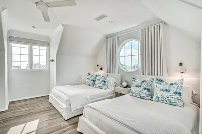 a white room with two beds and two windows at Elysee Reunion in Rosemary Beach