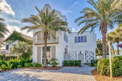 a villa with palm trees in front of it at Elysee Reunion in Rosemary Beach