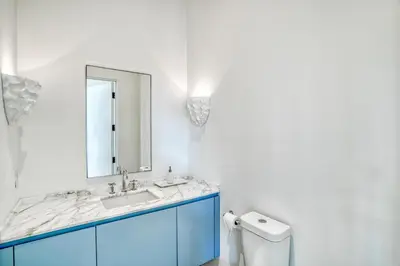 a bathroom with a blue sink and a mirror at Elysee Reunion in Rosemary Beach